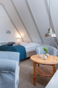 a bedroom with a bed and a table and chairs at Weisse Düne - West in Wenningstedt