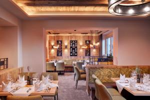 un restaurante con mesas y sillas y un bar en Hotel Neue Post, en Mayrhofen
