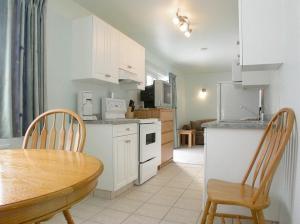 a kitchen with a table and chairs and a dining room at New Horizon Motel in Christina Lake