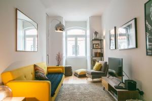リスボンにあるGrand Ouro Deluxe Apartment Downtown Baixaのリビングルーム(黄色のソファ、テレビ付)