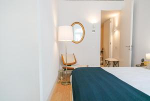 um quarto com uma cama, uma cadeira e um espelho em Grand Ouro Deluxe Apartment Downtown Baixa em Lisboa