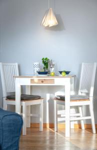 mesa de comedor blanca con 2 sillas y mesa blanca en Weisse Düne - App.. 4 en Wenningstedt