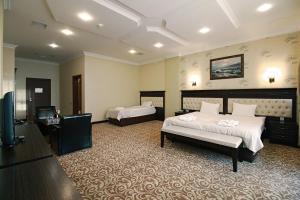 um quarto com 2 camas e uma televisão de ecrã plano em New Baku Hotel em Baku