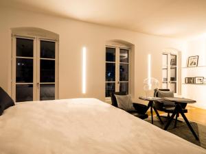 a bedroom with a bed and two chairs and a table at MiHotel Vieux Lyon in Lyon