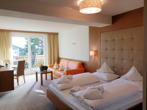 a bedroom with a large bed and a living room at Ruster Resort in Lagundo