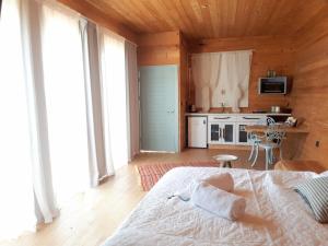 1 dormitorio con 1 cama blanca y cocina en צימרגולה, en ‘En Yahav