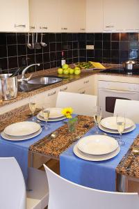 una cocina con una mesa con platos y copas de vino en Aparthotel Comtat Sant Jordi, en Platja d'Aro