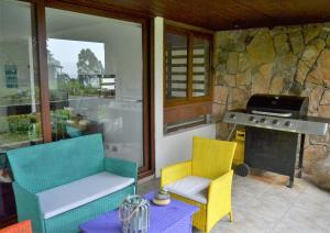 a patio with two chairs and a grill and a table at Departamento Maitencillo Costamai in Maitencillo