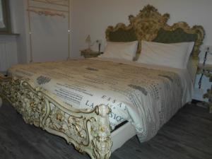 a bed with a gold and white comforter and pillows at Jackie O' a la maison in Bergamo