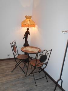 a table and chairs with a statue of a man with an umbrella at Jackie O' a la maison in Bergamo