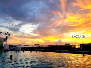 una persona nadando en el agua al atardecer en Sutera Avenue Kota Kinabalu By LAXZONE, en Sembulan 16 fotos más