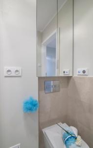 La salle de bains est pourvue d'un lavabo et d'une armoire blanche. dans l'établissement WLR Apartments - Świętokrzyska I, à Varsovie