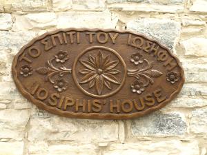 un signo de bronce en una pared de piedra en Iosiphis Stonebuilt House, en Pano Lefkara