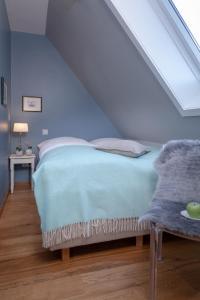 ein Schlafzimmer mit einem Bett mit einer blauen Decke in der Unterkunft Weisse Düne - App. 5 in Wenningstedt-Braderup