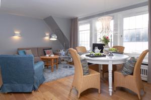 a living room and dining room with a table and chairs at Weisse Düne - App. 3 in Wenningstedt