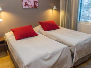 ターコブオリにあるHoliday Home Tahko spa standard suite white b 5 by Interhomeの赤い枕が備わる客室内のベッド2台