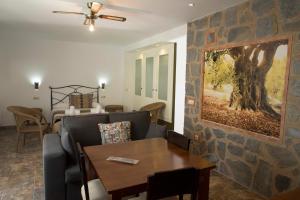 sala de estar con pared de piedra, sofá y mesa en Las Casas de Nani, en Beas de Segura