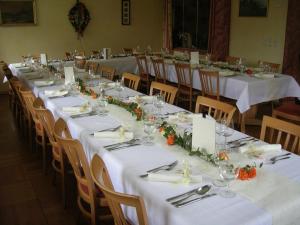 eine Gruppe von langen Tischen mit weißen Tischdecken und Blumen in der Unterkunft Gasthof Pension Leitner in Wildbad Einöd