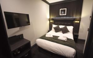 ロンドンにあるThe Pack And Carriage Londonのベッド1台、薄型テレビが備わるホテルルームです。