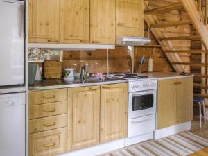 LahdenperäにあるHoliday Home Juvan-vuokko by Interhomeのキッチン(木製キャビネット、コンロ付)