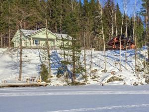 a house in the snow in front of a house at Holiday Home Koivurinne by Interhome in Vuoriniemi