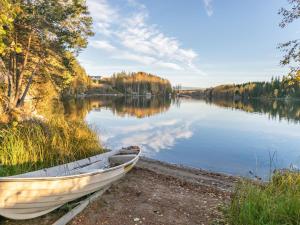 a boat sitting on the shore of a lake at Holiday Home Suvituuli by Interhome in Vuoriniemi