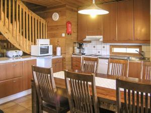 a kitchen with wooden cabinets and a table and chairs at Holiday Home Yläneuvola niemi by Interhome in Neuvola