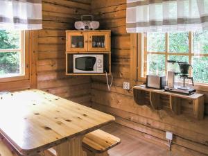 LahdenperäにあるHoliday Home Juvan-vuokko by Interhomeのテーブルと電子レンジ付きの木造の部屋