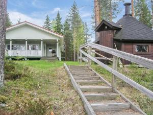 ein Haus mit einer Holztreppe, die zu einem Haus führt in der Unterkunft Holiday Home Yläneuvola silta by Interhome in Neuvola