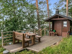 a wooden deck with a bench and a cabin at Holiday Home Illanvirkku by Interhome in Vuoriniemi