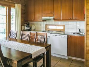eine Küche mit einem Holztisch und einem weißen Geschirrspüler in der Unterkunft Holiday Home Yläneuvola silta by Interhome in Neuvola