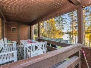un porche con sillas blancas y una mesa. en Holiday Home Suvituuli by Interhome, en Vuoriniemi