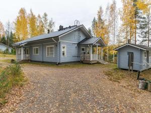 a blue house with a driveway in front of it at Holiday Home Nestori by Interhome in Vuoriniemi