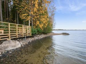 a wooden bridge next to a body of water at Holiday Home Aamuntorkku by Interhome in Vuoriniemi