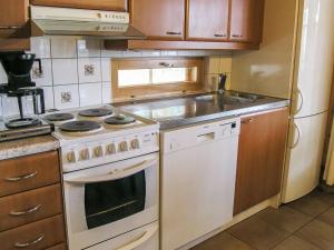 a kitchen with a white stove and a sink at Holiday Home Yläneuvola niemi by Interhome in Neuvola