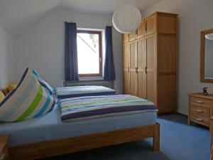 a bedroom with a bed with a window and blue curtains at Ferienwohnung am Weyer in Solingen
