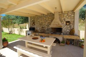 un patio con mesa y horno de piedra en Eleftheria Apartments, en Vlachata