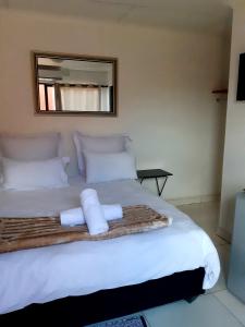 sypialnia z dużym białym łóżkiem z ręcznikami w obiekcie Niilo's Guesthouse w mieście Rundu