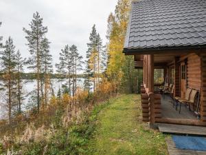uma cabana de madeira com um deque junto a um lago em Holiday Home Etelärinne by Interhome em Vuoriniemi