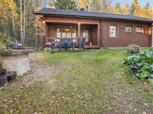a log cabin with a table and chairs in the yard at Holiday Home Suvituuli by Interhome in Vuoriniemi
