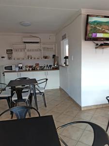 Pokój ze stołem i krzesłami oraz telewizorem na ścianie w obiekcie Niilo's Guesthouse w mieście Rundu