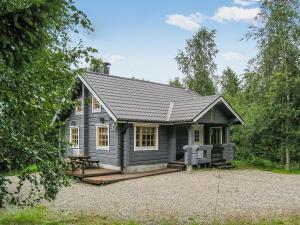 a small gray house with a picnic table in front of it at Holiday Home Juvan-vuokko by Interhome in Lahdenperä