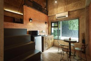 a kitchen with a small table and a kitchen with a window at The Step Chiang Mai in Chiang Mai