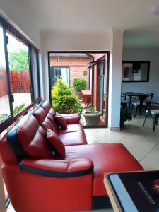 un soggiorno con divano in pelle rossa e tavolo di Niilo's Guesthouse a Rundu
