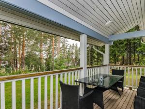a screened porch with a table and chairs on it at Holiday Home Kuutti by Interhome in Vuoriniemi