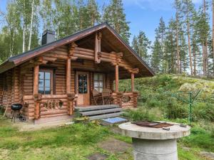 a log cabin cabin in the woods with a porch at Holiday Home Koivurinne by Interhome in Vuoriniemi