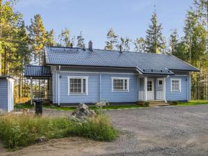 a blue house in the middle of a forest at Holiday Home Norppa by Interhome in Vuoriniemi