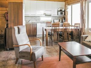 a living room and kitchen with a table and a chair at Holiday Home Yläneuvola lanssi by Interhome in Neuvola