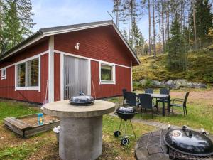a red cabin with a grill in front of it at Holiday Home Aamuntorkku by Interhome in Vuoriniemi