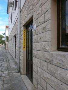 un bâtiment en briques avec une porte dans une rue dans l'établissement Guest House Zaninović, à Hvar